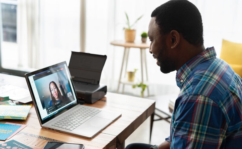 man sitting in front of laptop on video call